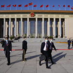 
              Attendees walk in front of the Great Hall of the People before the opening ceremony for the 20th National Congress of China's ruling Communist Party in Beijing, China, Sunday, Oct. 16, 2022. China on Sunday opens a twice-a-decade party conference at which leader Xi Jinping is expected to receive a third five-year term that breaks with recent precedent and establishes himself as arguably the most powerful Chinese politician since Mao Zedong. (AP Photo/Mark Schiefelbein)
            