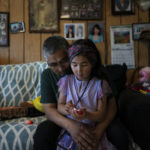 
              Alfred Ningeulook, 61, hugs his granddaughter, Glenna, 6, in his home in Shishmaref, Alaska, Sunday, Oct. 2, 2022. Rising sea levels, flooding, increased erosion and loss of protective sea ice and land have led residents of this island community to vote twice to relocate. But more than six years after the last vote, Shishmaref remains in the same place because the relocation is too costly. (AP Photo/Jae C. Hong)
            