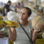 
              FILE - Vegetable vendor Maria do Carmo who hawks her products at a local market, says her stall has done much better in recent months as residents suddenly had some cash to spend due to an increase in a welfare program's benefits, in Aracuai, in the Jequitinhonha Valley, Minas Gerais state, Brazil, Oct. 11, 2022. "I'm not saying these people should get free money forever; they need to work. But it is a temporary solution that helps us, too," said do Carmo, whose daughter is a pro-Bolsonaro city councilor. (AP Photo/Andre Penner, File)
            