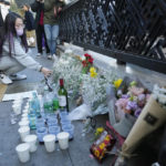 
              A woman places a bouquet of flowers to pay tribute for victims near the scene of a deadly accident in Seoul, South Korea, Sunday, Oct. 30, 2022, following Saturday night's Halloween festivities. A mass of mostly young people among tens of thousands who gathered to celebrate Halloween in Seoul became trapped and crushed as the crowd surged into a narrow alley, killing dozens of people and injuring dozens of others in South Korea’s worst disaster in years. (AP Photo/Ahn Young-joon)
            