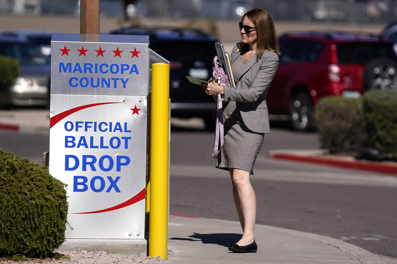 A voter places a ballot in an election voting drop box in Mesa, Ariz., Friday, Oct. 28, 2022. (AP P...