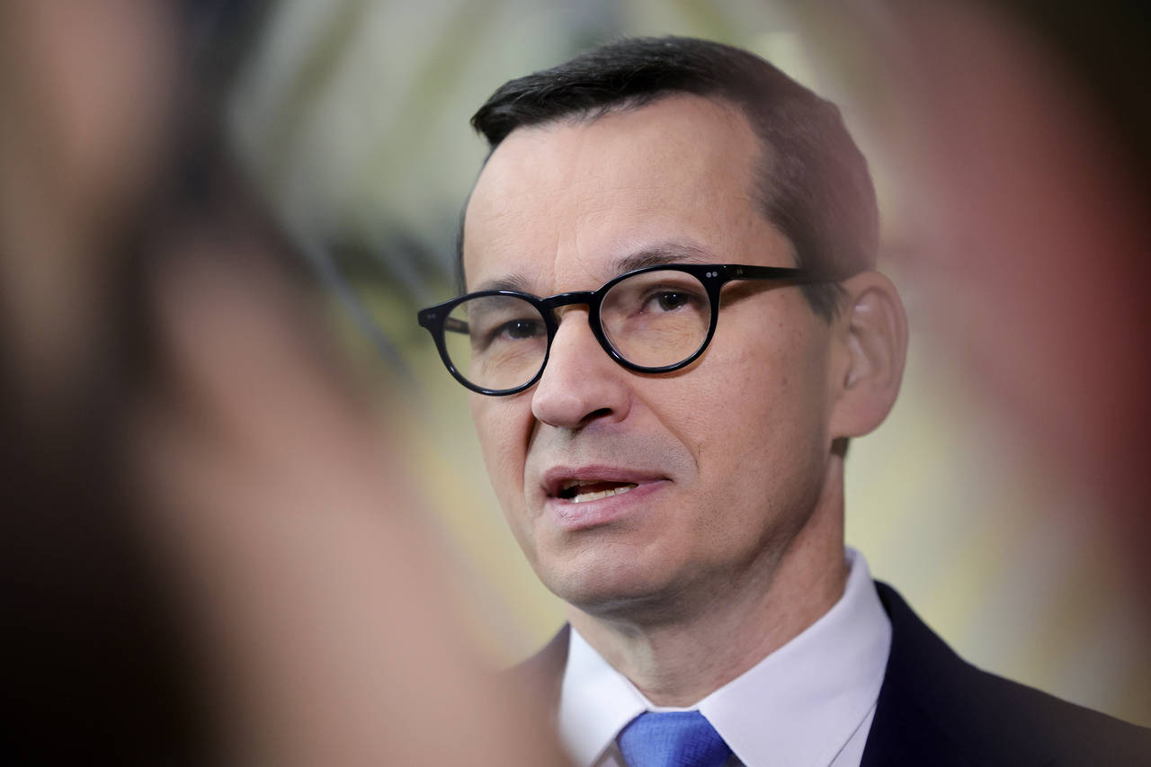 FILE - Poland's Prime Minister Mateusz Morawiecki speaks with the media as he arrives for an EU sum...