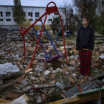 
              Taisiia Kovaliova, 15, stands amongst the rubble of a playground in front of her house hit by a Russian missile in Mykolaiv, Sunday, Oct. 23, 2022. "I spent all my childhood and life at this courtyard, I already feel nostalgic. I went to this swing that stood it all" Taisiia said. (AP Photo/Emilio Morenatti)
            
