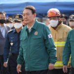 
              South Korean President Yoon Suk Yeol, center, visits the scene where dozens of people died and were injured in Seoul, South Korea, Sunday, Oct. 30, 2022, after a mass of mostly young people celebrating Halloween festivities became trapped and crushed as the crowd surged into a narrow alley. (AP Photo/Lee Jin-man)
            