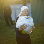 
              A local woman carries a bag with food given by Ukrainian volunteers in recently retaken Pidlyman village, east Ukraine, Friday, Oct. 7, 2022. (AP Photo/Francisco Seco)
            