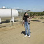 
              Madeline Harris, policy manager with the advocacy group Leadership Council for Justice and Accountability, stands next to a municipal well that's gone dry in Fairmead, Calif., Sept. 14, 2022. “Municipal wells like this one are being put at risk and are going dry because of the groundwater overdraft problems from agriculture,” Harris said. “There are families who don’t have access to running water right now because they have dry domestic wells." (AP Photo/Terry Chea)
            