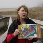 
              Kimberly McKenna, of the Coastal Research Center, points out some flood prone areas on a map while talking to reporters in Atlantic City, N.J., Wednesday, May 4, 2022. Some cities around the world are pulling back from shorelines, as rising seas from climate change increase flooding. But so far, retreat appears out of the question for Atlantic City. She says most of the increased flooding in Atlantic City happens in the part of the island that faces the mainland, called the back bay. (AP Photo/Seth Wenig)
            