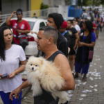 
              Voters line up outside a polling station during general elections in Rio de Janeiro, Brazil, Sunday, Oct. 2, 2022. (AP Photo/Matias Delacroix)
            