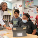 
              Teacher Arleen Franklin explains a math lesson to her students at Judy Nelson Elementary School on Sept. 21, 2022, in Kirtland, N.M. The closure of the nearby San Juan Generating Station and an adjacent mine is resulting in the loss of hundreds of jobs and tax revenue for the Central Consolidated School District, which serves mostly Native American students. (AP Photo/Susan Montoya Bryan)
            