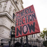 
              A placard is placed outside the gates of Downing Street, in London, Saturday, Oct. 22, 2022. While the opposition Labour Party is demanding an election, the governing conservatives are pushing on with choosing another prime minister from within their own ranks, which they have the right to do because of the way Britain's parliamentary democracy works. (AP Photo/Alberto Pezzali)
            