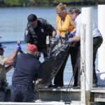 
              Rescue personnel lift a body recovered from Sanibel Island to a dock for transport to the medical examiner Saturday, Oct. 1, 2022, in Fort Myers, Fla. (AP Photo/Steve Helber)
            