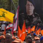 
              Supporters of Lebanese President Michel Aoun hold his portrait as he delivers a speech outside the presidential palace in Baabda, east of Beirut, Lebanon, Sunday, Oct. 30, 2022. Aoun left Lebanon's presidential palace Sunday marking the end of his six-year term without a replacement, leaving the small nation in a political vacuum that is likely to worsen its historic economic meltdown. (AP Photo/Bilal Hussein)
            