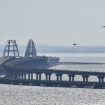 
              Two helicopters fly to drop water to stop fire on Crimean Bridge connecting Russian mainland and Crimean peninsula over the Kerch Strait, in Kerch, Crimea, Saturday, Oct. 8, 2022. Russian authorities say a truck bomb has caused a fire and the collapse of a section of a bridge linking Russia-annexed Crimea with Russia. The bridge is a key supply artery for Moscow's faltering war effort in southern Ukraine. (AP Photo)
            