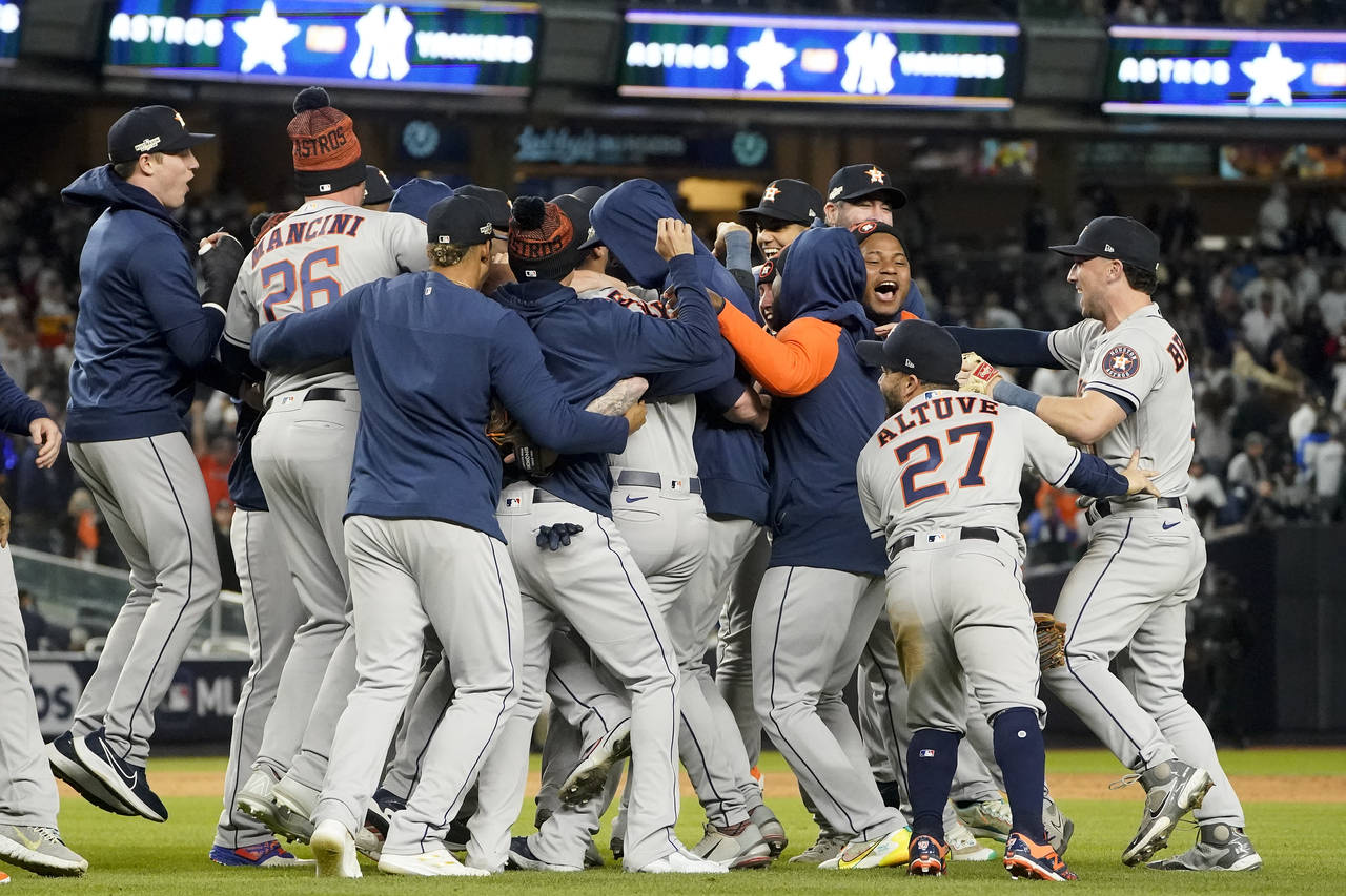 The Houston Astros celebrate after defeating the New York Yankees 6-5 to win Game 4 and the America...