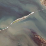 
              This satellite image provided by Maxar Technologies shows damage to the Kerch Bridge, which connects the Crimean Peninsula, top right, with Russia, bottom left, crossing a strait between the Black Sea and the Sea of Azov, and rail cars on fire, upper right, on Saturday, Oct. 8, 2022. North is towards the right. (Maxar Technologies via AP)
            