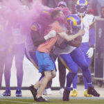 
              A protester is hit by Los Angeles Rams defensive end Takkarist McKinley, middle left, and linebacker Bobby Wagner during the first half of an NFL football game between the San Francisco 49ers and the Rams in Santa Clara, Calif., Monday, Oct. 3, 2022. (AP Photo/Godofredo A. Vásquez)
            