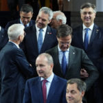 
              Austria's Chancellor Karl Nehammer, center, speaks with Latvia's Prime Minister Krisjanis Karins, center left, during a group photo during an EU Summit at Prague Castle in Prague, Czech Republic, Friday, Oct 7, 2022. European Union leaders converged on Prague Castle Friday to try to bridge significant differences over a natural gas price cap as winter approaches and Russia's war on Ukraine fuels a major energy crisis. (AP Photo/Petr David Josek)
            