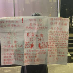 A protester holds up a banner commemorating the victims of a recent Urumqi deadly fire with other demands against the zero-Covid system and calls for media freedom in Central in Hong Kong, Monday, Nov. 28, 2022. Students in Hong Kong chanted "oppose dictatorship" in a protest against China's anti-virus controls after crowds in mainland cities called for President Xi Jinping to resign in the biggest show of opposition to the ruling Communist Party in decades. (AP Photo/Zen Soo)