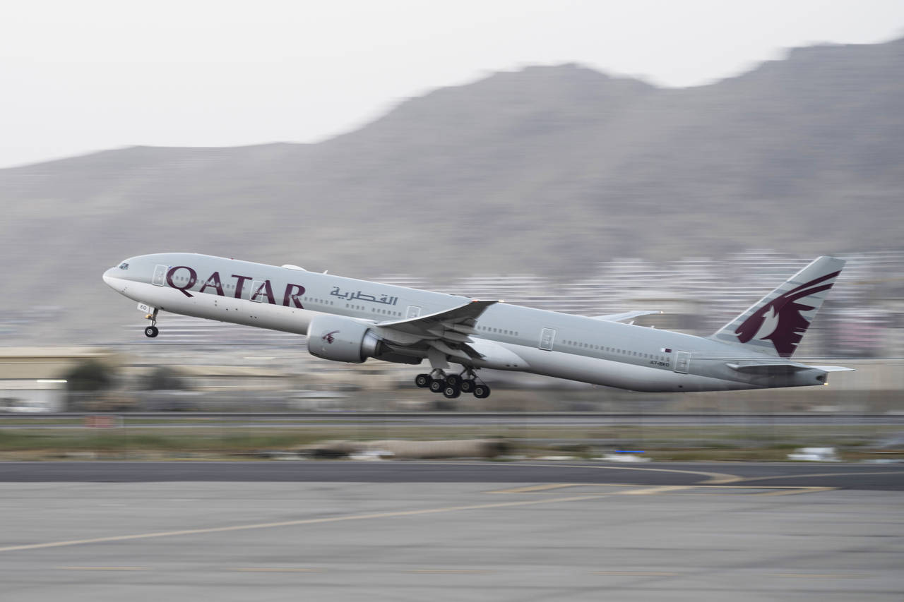 FILE - A Qatar Airways aircraft takes off with foreigners from the airport in Kabul, Afghanistan, o...