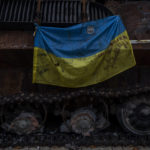 
              A Ukrainian flag with messages of support for cities of eastern Ukraine hangs from a destroyed Russian tank displayed in downtown Kyiv, Ukraine, Monday, Nov. 7, 2022. (AP Photo/Bernat Armangue)
            