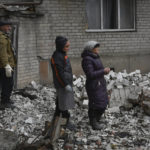 
              Local residents react near the destroyed house after recent Russian air strike in Chasiv Yar, Ukraine, Sunday, Nov. 27, 2022. Shelling by Russian forces struck several areas in eastern and southern Ukraine overnight as utility crews continued a scramble to restore power, water and heating following widespread strikes in recent weeks, officials said Sunday. (AP Photo/Andriy Andriyenko)
            
