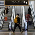 
              Travelers ride escalators in a terminal at Ronald Reagan Washington National Airport in Arlington, Va., Wednesday, Nov. 23, 2022. (AP Photo/Patrick Semansky)
            