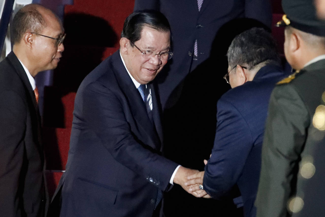 Cambodia's Prime Minister Hun Sen, center,  arrives at Ngurah Rai International Airport ahead of th...