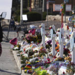 
              A visitor looks over a makeshift memorial near the scene of a mass shooting at a gay nightclub Wednesday, Nov. 23, 2022, in Colorado Springs, Colo.  The alleged shooter facing possible hate crime charges in the fatal shooting of five people at a Colorado Springs gay nightclub is scheduled to make their first court appearance Wednesday from jail after being released from the hospital a day earlier.  (AP Photo/David Zalubowski)
            