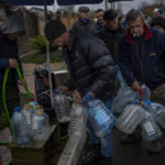 
              Residents fill containers with drinking water in Kherson, southern Ukraine, Sunday, Nov. 20, 2022. Russian forces fired tank shells, rockets and other artillery on the city of Kherson, which was recently liberated from Ukrainian forces. (AP Photo/Bernat Armangue)
            