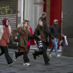 
              People leave the area after an explosion on Istanbul's popular pedestrian Istiklal Avenue Sunday, Istanbul, Sunday, Nov. 13, 2022. A bomb exploded on a major pedestrian avenue in the heart of Istanbul on Sunday, killing six people, wounding dozens and sending people fleeing as flames rose. (AP Photo/Can Ozer)
            
