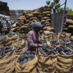 
              FILE - A woman works at a coal depot in Ahmedabad, India, May 2, 2022. The question of whether the conflict in Ukraine will hasten or hinder the shift from fossil fuels to clean energy needed to keep global temperatures from reaching dangerous heights looms large ahead of next week's U.N. climate conference. (AP Photo/Ajit Solanki, File)
            