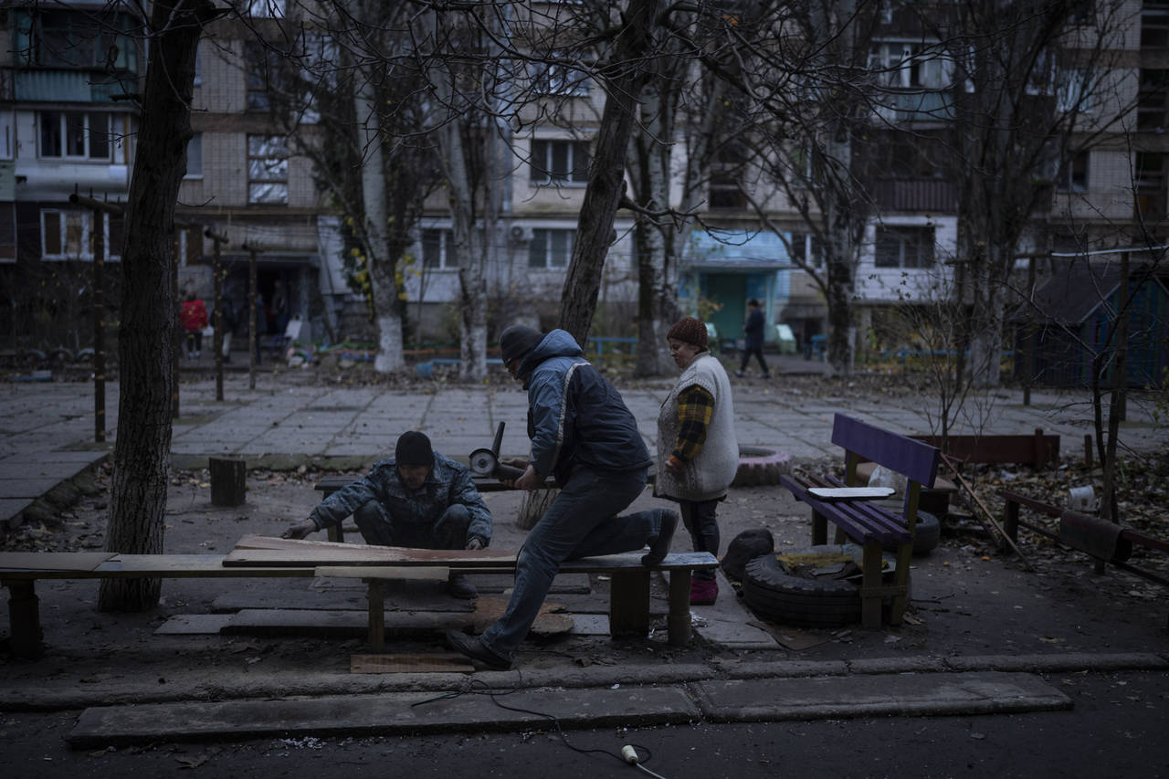 Residents do repair works on a recently damaged building during a Russian strike in the southern ci...