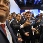 
              French President Emmanuel Macron poses for a selfie at the COP27 climate summit in Sharm el-Sheikh, Egypt, Monday, Nov. 7, 2022. Nearly 50 heads of states or governments on Monday will take the stage in the first day of "high-level" international climate talks in Egypt with more to come in the following days. (Ludovic Marin, Pool via AP)
            
