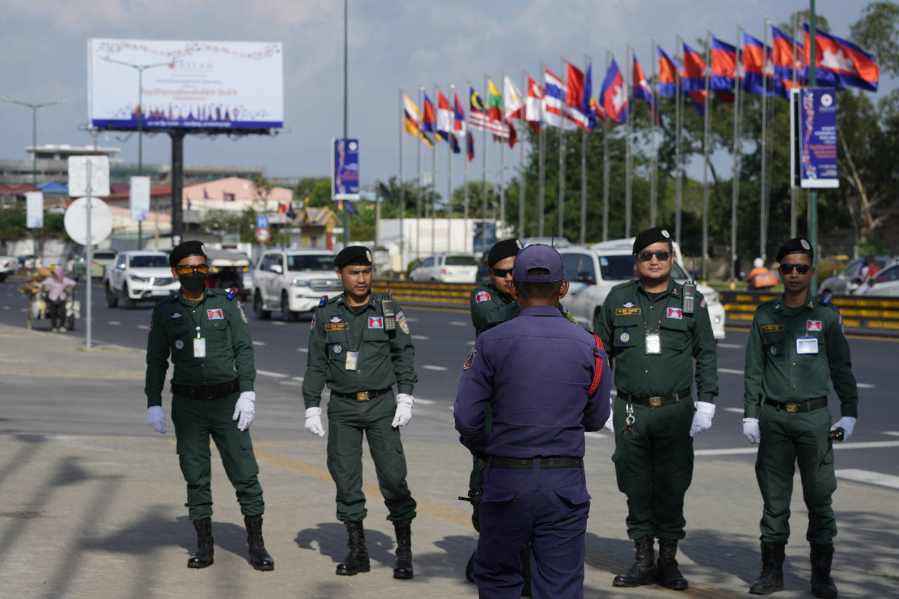 Police officers pose for a souvenir in a group photo as they guard near the Phnom Penh Internationa...