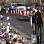 
              Visitors scan the makeshift memorial near the scene of a mass shooting at a gay nightclub Wednesday, Nov. 23, 2022, in Colorado Springs, Colo. The alleged shooter facing possible hate crime charges in the fatal shooting of five people at a Colorado Springs gay nightclub is scheduled to make their first court appearance Wednesday from jail after being released from the hospital a day earlier. (AP Photo/David Zalubowski)
            