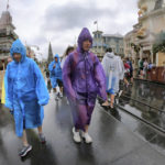 
              Guests brave the weather in the Magic Kingdom at Walt Disney World in Lake Buena Vista, Fla., Wednesday, Nov. 9, 2022, as conditions deteriorate with the approach of Hurricane Nicole. All 4 Disney parks in Central Florida closed early Wednesday because of the impending storm. (Joe Burbank/Orlando Sentinel via AP)
            