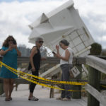 
              People visit the beach to investigate storm damage, including a lifeguard station that was displaced onto a dune, following the passage of Hurricane Nicole, Thursday, Nov. 10, 2022, in Vero Beach, Fla. (AP Photo/Rebecca Blackwell)
            