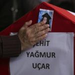 
              A person poses his hand on a photo of Yagmur Ucar, the 15-year-old daughter of Arzu Ozsoy, both of them dead in Sunday's explosion occurred on Istiklal avenue, during their funeral in Istanbul, Turkey, Monday, Nov. 14, 2022. Turkish police said Monday that they have detained a Syrian woman with suspected links to Kurdish militants and that she confessed to planting a bomb that exploded on a bustling pedestrian avenue in Istanbul, killing six people and wounding several dozen others. (AP Photo/Emrah Gurel)
            