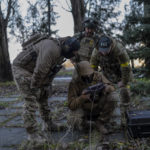 
              Sniper and commander of a unit in the south, alias Kurt, left, checks real-time drone footage during an operation against Russian positions, Kherson region, southern Ukraine, Saturday, Nov. 19, 2022. (AP Photo/ Bernat Armangue)
            