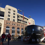 
              Fans walk near the Nebraska team bus following the players' arrival at Memorial Stadium before an NCAA college football game against Minnesota on Saturday, Nov. 5, 2022, in Lincoln, Neb. Nebraska expects to spend $9.2 million on athletic department travel this year, executive associate athletic director and CFO Doug Ewald said. That’s a 17% increase, or $1.3 million. (AP Photo/Rebecca S. Gratz)
            
