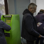 
              Residents operate ATMs inside a bank branch in Kherson, southern Ukraine, Monday, Nov. 21, 2022. (AP Photo/Bernat Armangue)
            
