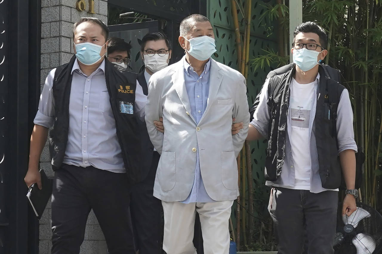 FILE - Hong Kong media tycoon Jimmy Lai, center, who founded local newspaper Apple Daily, is arrest...