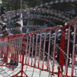
              Police stand a guard behind razor wire during a demonstration near the Asia-Pacific Economic Cooperation (APEC) forum venue, Thursday, Nov. 17, 2022, in Bangkok, Thailand. A small but noisy group of protesters scuffled briefly with police demanding to deliver a letter to leaders attending the summit demanding various causes including removal of Prime Minister Prayuth Chan-ocha and abolition of Thailand's strict royal defamation laws. (AP Photo/Sarot Meksophawannakul)
            