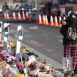 
              Visitors hug at makeshift memorial near the scene of a mass shooting at a gay nightclub Wednesday, Nov. 23, 2022, in Colorado Springs, Colo.  The alleged shooter facing possible hate crime charges in the fatal shooting of five people at a Colorado Springs gay nightclub is scheduled to make their first court appearance Wednesday from jail after being released from the hospital a day earlier.  (AP Photo/David Zalubowski)
            