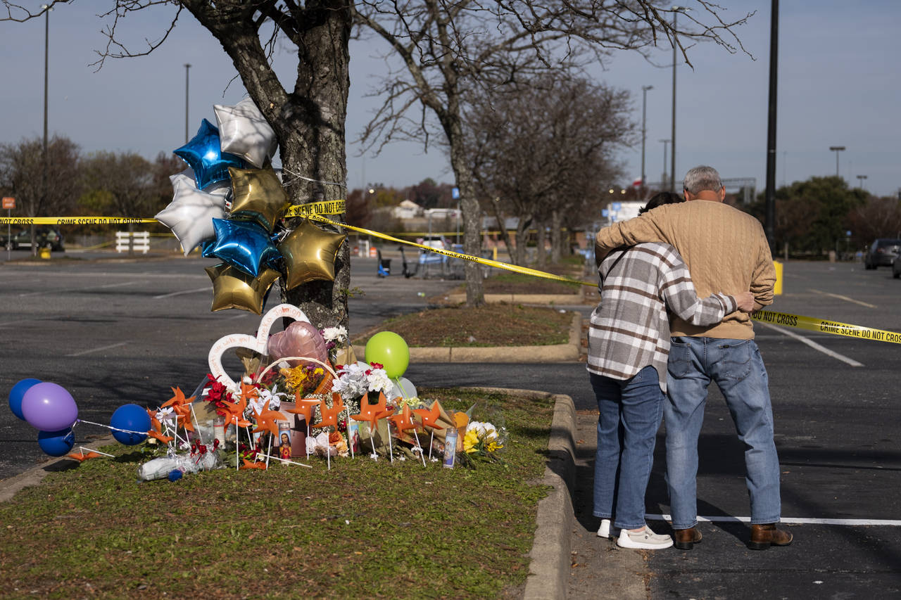 Debbie, left, and Chet Barnett place flowers at a memorial outside of the Chesapeake, Va., Walmart ...
