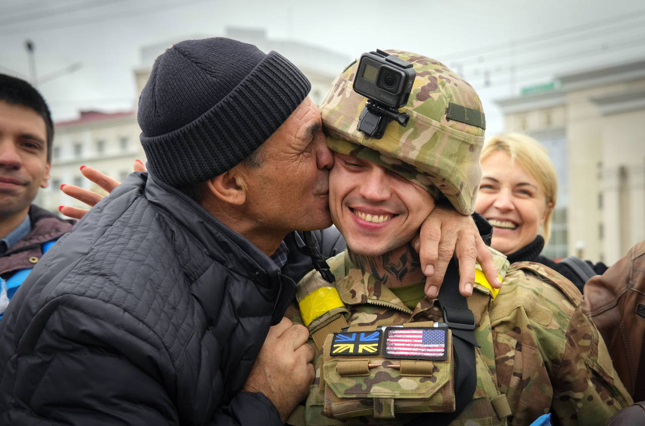 A Kherson resident kisses a Ukrainian soldier in central Kherson, Ukraine, Sunday, Nov. 13, 2022. T...
