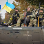 
              Ukrainian soldiers sit in a pickup in central Kherson, Ukraine, Sunday, Nov. 13, 2022. The Russian retreat from Kherson marked a triumphant milestone in Ukraine's pushback against Moscow's invasion almost nine months ago. (AP Photo/Efrem Lukatsky)
            