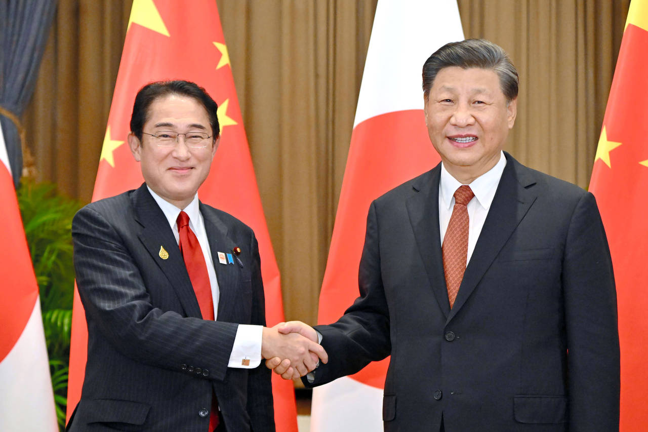 FILE - Japanese Prime Minister Fumio Kishida, left, and Chinese President Xi Jinping shake hands du...