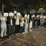 
              Protesters hold up blank white papers during a commemoration for victims of a recent Urumqi deadly fire at the Chinese University of Hong Kong in Hong Kong, Monday, Nov. 28, 2022. Students in Hong Kong chanted “oppose dictatorship” in a protest against China’s anti-virus controls after crowds in mainland cities called for President Xi Jinping to resign in the biggest show of opposition to the ruling Communist Party in decades. (AP Photo/Kanis Leung)
            