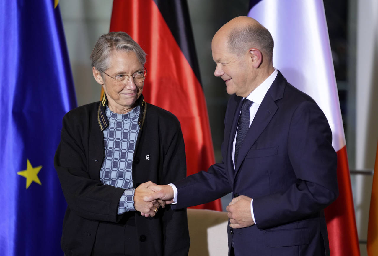 German Chancellor Olaf Scholz, right, and the Prime Minister of France, Elisabeth Borne, left, shak...